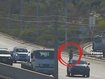 One of the women is carrying a small child as she dodges traffic.